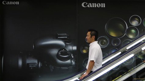 A man takes a downward escalator in front of an advertisement of Canon digital cameras at an electronics retail store in Tokyo July 24, 2013 A man takes a downward escalator in front of an advertisement of Canon digital cameras at an electronics retail store in Tokyo July 24, 2013