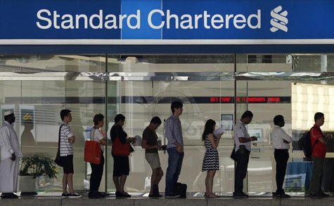 People queue up outside a Standard Chartered Bank branch before operation hours at the central business district in Singapore January 23, 20 People queue up outside a Standard Chartered Bank branch before operation hours at the central business district in Singapore January 23, 20