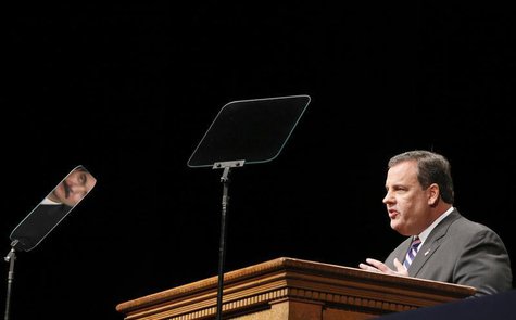 New Jersey Governor Chris Christie delivers an address as Democratic New Jersey Assemblyman Vincent Prieto looks on as he is reflected in a New Jersey Governor Chris Christie delivers an address as Democratic New Jersey Assemblyman Vincent Prieto looks on as he is reflected in a