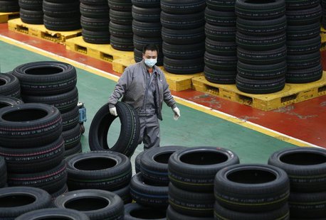 An employee carries a tyre at a tyre factory in Jiaxing, Zhejiang Province, January 27, 2014. REUTERS/William Hong An employee carries a tyre at a tyre factory in Jiaxing, Zhejiang Province, January 27, 2014. REUTERS/William Hong