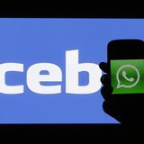 A woman holds a smartphone displaying WhatApps' logo in front of the screen with the Facebook logo in this photo illustration taken in Pragu A woman holds a smartphone displaying WhatApps' logo in front of the screen with the Facebook logo in this photo illustration taken in Pragu
