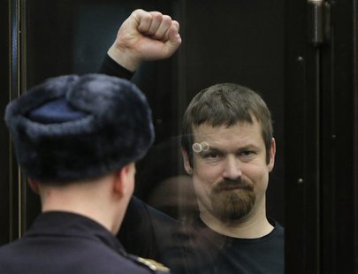Leonid Razvozzhayev, co-defendant of opposition leader Sergei Udaltsov, gestures from the defendants cage during a court hearing in Moscow F Leonid Razvozzhayev, co-defendant of opposition leader Sergei Udaltsov, gestures from the defendants cage during a court hearing in Moscow F