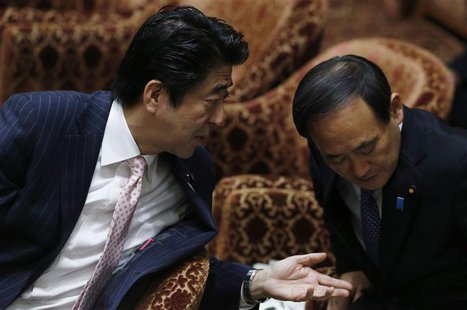 Japan's Prime Minister Shinzo Abe (L) speaks to Chief Cabinet Secretary Yoshihide Suga before Suga answers questions during a lower house bu Japan's Prime Minister Shinzo Abe (L) speaks to Chief Cabinet Secretary Yoshihide Suga before Suga answers questions during a lower house bu