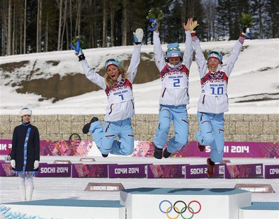 Winner Norway's Marit Bjoergen (C) celebrates next to her compatriots, second placed Therese Johaug (L) and third placed Kristin Stoermer St Winner Norway's Marit Bjoergen (C) celebrates next to her compatriots, second placed Therese Johaug (L) and third placed Kristin Stoermer St