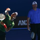Novak Djokovic of Serbia serves as his coach Boris Becker of Germany watches during a practice session at the Australian Open 2014 tennis to Novak Djokovic of Serbia serves as his coach Boris Becker of Germany watches during a practice session at the Australian Open 2014 tennis to
