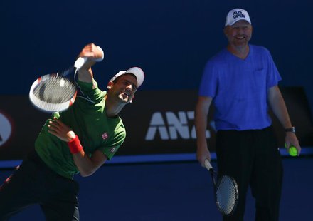 Novak Djokovic of Serbia serves as his coach Boris Becker of Germany watches during a practice session at the Australian Open 2014 tennis to Novak Djokovic of Serbia serves as his coach Boris Becker of Germany watches during a practice session at the Australian Open 2014 tennis to