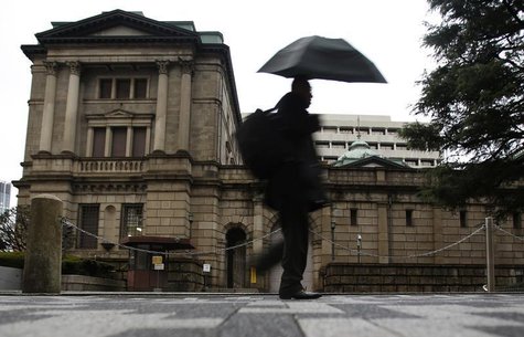 A pedestrian holding an umbrella to take shelter from rain and hail walks past the Bank of Japan headquarters building in Tokyo December 20, A pedestrian holding an umbrella to take shelter from rain and hail walks past the Bank of Japan headquarters building in Tokyo December 20,