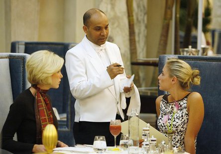 Waiter Sayed Islam (C) speaks with Kelley Ruland (R) and Brittany Parker in "The Plaza" hotel's "Palm Court" the first day that the hotel re Waiter Sayed Islam (C) speaks with Kelley Ruland (R) and Brittany Parker in "The Plaza" hotel's "Palm Court" the first day that the hotel re