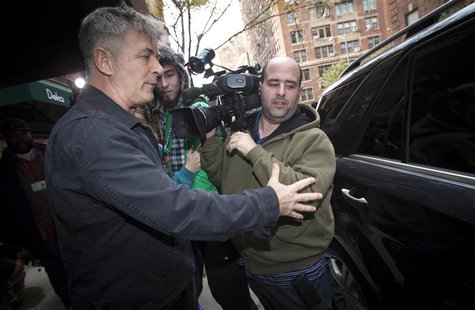 Actor Alec Baldwin directs a TV photographer out of his way in front of his apartment building in New York November 15, 2013. REUTERS/Carlo Actor Alec Baldwin directs a TV photographer out of his way in front of his apartment building in New York November 15, 2013. REUTERS/Carlo