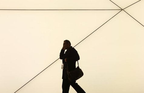 A man talks by a mobile phone as he walks past the Samsung stand at the Mobile World Congress in Barcelona February 24, 2014. REUTERS/Albert A man talks by a mobile phone as he walks past the Samsung stand at the Mobile World Congress in Barcelona February 24, 2014. REUTERS/Albert