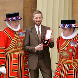 British cyclist Bradley Wiggins poses for a photograph with his Knighthood medal, and Yeomen of the Guard, awarded to him by Queen Elizabeth British cyclist Bradley Wiggins poses for a photograph with his Knighthood medal, and Yeomen of the Guard, awarded to him by Queen Elizabeth