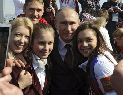 Russian President Vladimir Putin (C) and Russian Olympic medal winning athletes pose for a picture in Sochi February 24, 2014. REUTERS/Mikha Russian President Vladimir Putin (C) and Russian Olympic medal winning athletes pose for a picture in Sochi February 24, 2014. REUTERS/Mikha