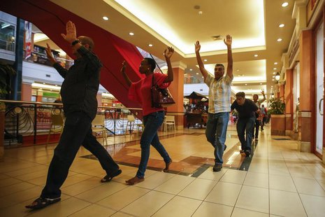 Shoppers and shop assistants raise their hands as they are escorted to safety while armed police hunt for gunmen who went on a shooting spre Shoppers and shop assistants raise their hands as they are escorted to safety while armed police hunt for gunmen who went on a shooting spre