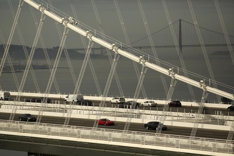 The Golden Gate Bridge is seen in the background as vehicles travel on the new east span of the San Francisco Oakland Bay Bridge in Oakland, The Golden Gate Bridge is seen in the background as vehicles travel on the new east span of the San Francisco Oakland Bay Bridge in Oakland,