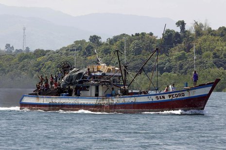 Filipino fishermen wave from a fishing boat bound to fish near Scarborough Shoal in Masinloc, Zambales May 10, 2012. REUTERS/Erik De Castro Filipino fishermen wave from a fishing boat bound to fish near Scarborough Shoal in Masinloc, Zambales May 10, 2012. REUTERS/Erik De Castro
