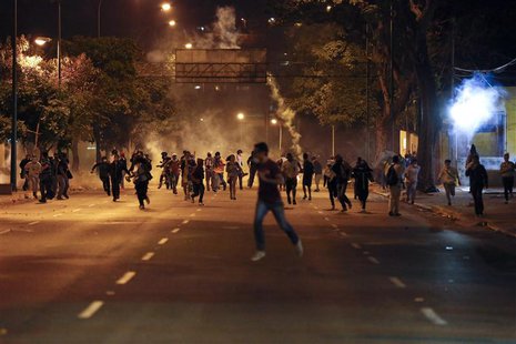 Anti-government demonstrators run from tear gas during clashes with riot police at Altamira Square in Caracas February 24, 2014. REUTERS/Car Anti-government demonstrators run from tear gas during clashes with riot police at Altamira Square in Caracas February 24, 2014. REUTERS/Car
