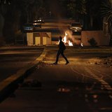 A woman walks past a burning barricade at Altamira Square in Caracas February 24, 2014. REUTERS/Carlos Garcia Rawllins A woman walks past a burning barricade at Altamira Square in Caracas February 24, 2014. REUTERS/Carlos Garcia Rawllins