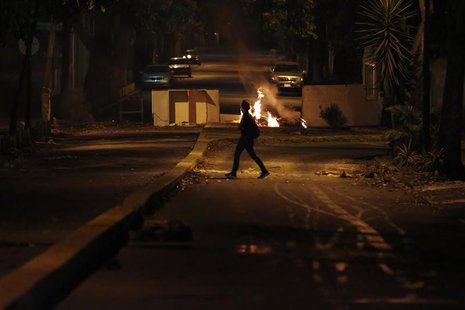 A woman walks past a burning barricade at Altamira Square in Caracas February 24, 2014. REUTERS/Carlos Garcia Rawllins A woman walks past a burning barricade at Altamira Square in Caracas February 24, 2014. REUTERS/Carlos Garcia Rawllins