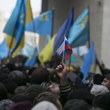 An ethnic Russian Ukrainian holds a Russian flag as Crimean Tatars rally near the Crimean parliament building in Simferopol February 26, 201 An ethnic Russian Ukrainian holds a Russian flag as Crimean Tatars rally near the Crimean parliament building in Simferopol February 26, 201