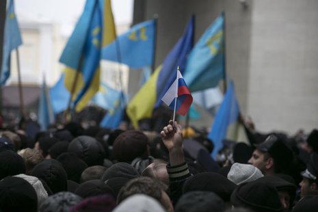 An ethnic Russian Ukrainian holds a Russian flag as Crimean Tatars rally near the Crimean parliament building in Simferopol February 26, 201 An ethnic Russian Ukrainian holds a Russian flag as Crimean Tatars rally near the Crimean parliament building in Simferopol February 26, 201