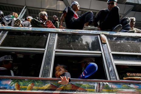 A child waves as he gathers with others during a rally outside the Royal Thai Police headquarters in central Bangkok February 26, 2014. REUT A child waves as he gathers with others during a rally outside the Royal Thai Police headquarters in central Bangkok February 26, 2014. REUT
