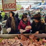 Customers select pork products under a price tag at a supermarket in Hangzhou, Zhejiang province January 9, 2014. REUTERS/China Daily Customers select pork products under a price tag at a supermarket in Hangzhou, Zhejiang province January 9, 2014. REUTERS/China Daily