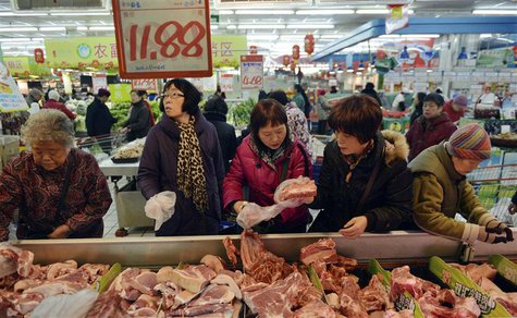 Customers select pork products under a price tag at a supermarket in Hangzhou, Zhejiang province January 9, 2014. REUTERS/China Daily Customers select pork products under a price tag at a supermarket in Hangzhou, Zhejiang province January 9, 2014. REUTERS/China Daily