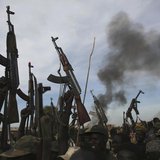 Rebel fighters hold up their rifles as they walk in front of a bushfire in a rebel controlled territory in Upper Nile State February 13, 201 Rebel fighters hold up their rifles as they walk in front of a bushfire in a rebel controlled territory in Upper Nile State February 13, 201