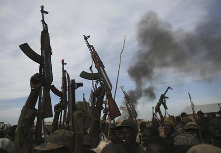 Rebel fighters hold up their rifles as they walk in front of a bushfire in a rebel controlled territory in Upper Nile State February 13, 201 Rebel fighters hold up their rifles as they walk in front of a bushfire in a rebel controlled territory in Upper Nile State February 13, 201