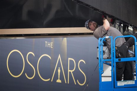 A man sets a digital display above the red carpet during preparations for the 86th Academy Awards in Hollywood, California February 26, 2014 A man sets a digital display above the red carpet during preparations for the 86th Academy Awards in Hollywood, California February 26, 2014