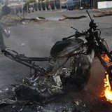 An anti-government demonstrator walks behind a burning motorcycle during a protest in San Cristobal, about 410 miles (660 km) southwest of C An anti-government demonstrator walks behind a burning motorcycle during a protest in San Cristobal, about 410 miles (660 km) southwest of C