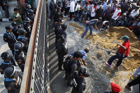 Government supporters begin to build a wall at the gates of the National Anti-Corruption Commission (NACC) office as policemen guard it in N Government supporters begin to build a wall at the gates of the National Anti-Corruption Commission (NACC) office as policemen guard it in N
