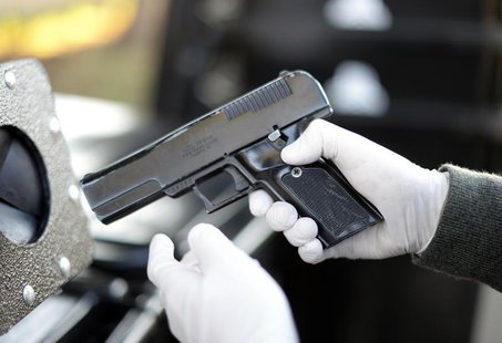A Los Angeles Police Department officer inspects a handgun in Los Angeles, California, December 14, 2013. REUTERS/Kevork Djansezian A Los Angeles Police Department officer inspects a handgun in Los Angeles, California, December 14, 2013. REUTERS/Kevork Djansezian