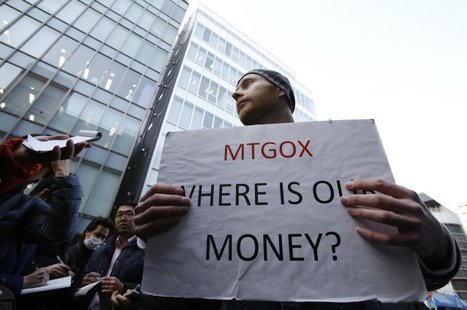 Kolin Burges, a self-styled cryptocurrency trader and former software engineer from London, holds a placard to protest against Mt. Gox, in f Kolin Burges, a self-styled cryptocurrency trader and former software engineer from London, holds a placard to protest against Mt. Gox, in f