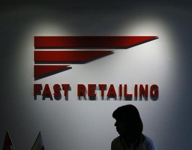 An employee of Fast Retailing Co, operator of the Uniqlo budget fashion chain, is silhouetted in front of its logo at its headquarters in To An employee of Fast Retailing Co, operator of the Uniqlo budget fashion chain, is silhouetted in front of its logo at its headquarters in To