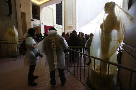 Tourists wearing rain gear stand next to Oscar statues covered with plastic during preparations for the 86th Academy Awards at the Dolby The Tourists wearing rain gear stand next to Oscar statues covered with plastic during preparations for the 86th Academy Awards at the Dolby The