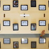 An employee rests a hand on a table displaying iPads as part of the display is reflected on a glass surface at the Passeig de Gracia Apple s An employee rests a hand on a table displaying iPads as part of the display is reflected on a glass surface at the Passeig de Gracia Apple s