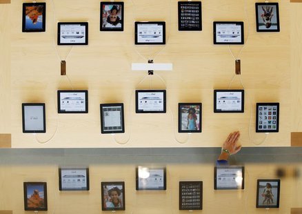 An employee rests a hand on a table displaying iPads as part of the display is reflected on a glass surface at the Passeig de Gracia Apple s An employee rests a hand on a table displaying iPads as part of the display is reflected on a glass surface at the Passeig de Gracia Apple s