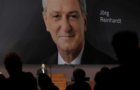 Designated successor Joerg Reinhardt is seen on a huge TV screen as outgoing Chairman of Swiss drug maker Novartis Daniel Vasella addresses Designated successor Joerg Reinhardt is seen on a huge TV screen as outgoing Chairman of Swiss drug maker Novartis Daniel Vasella addresses