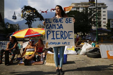 Anti-government protesters, dressed as Carnival revellers, block a street as they stage a mock beach during a protest at Altamira square in Anti-government protesters, dressed as Carnival revellers, block a street as they stage a mock beach during a protest at Altamira square in