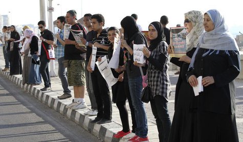 Demonstrators stand in silence on the second anniversary of the death of Egyptian Khaled Said as they carry his photo in front his house in Demonstrators stand in silence on the second anniversary of the death of Egyptian Khaled Said as they carry his photo in front his house in