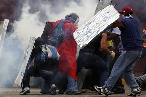 Anti-government protesters shield themselves from tear gas during a rally in Caracas March 2, 2014. REUTERS/Jorge Silva Anti-government protesters shield themselves from tear gas during a rally in Caracas March 2, 2014. REUTERS/Jorge Silva