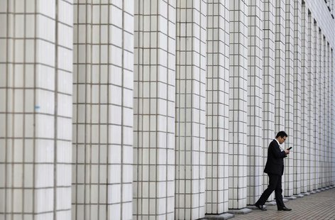 A man walks out from a business building in Tokyo January 24, 2013. REUTERS/Toru Hanai A man walks out from a business building in Tokyo January 24, 2013. REUTERS/Toru Hanai