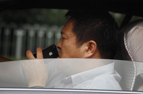 A man uses his iPhone as he drives a car along a main road in central Beijing September 24, 2012.
CREDIT: REUTERS/DAVID GRAY A man uses his iPhone as he drives a car along a main road in central Beijing September 24, 2012.
CREDIT: REUTERS/DAVID GRAY