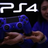 A staff at the PlayStation 4 launch event poses with PlayStation 4's game controller before its domestic launch event at the Sony Showroom i A staff at the PlayStation 4 launch event poses with PlayStation 4's game controller before its domestic launch event at the Sony Showroom i