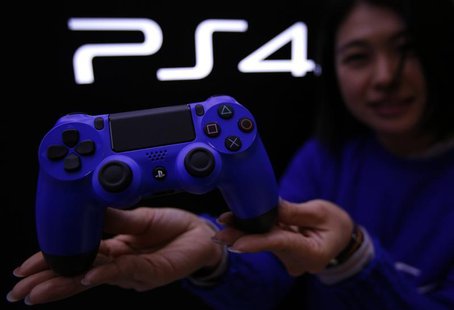 A staff at the PlayStation 4 launch event poses with PlayStation 4's game controller before its domestic launch event at the Sony Showroom i A staff at the PlayStation 4 launch event poses with PlayStation 4's game controller before its domestic launch event at the Sony Showroom i