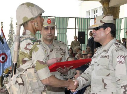 Egypt's army chief Field Marshal Abdel Fattah al-Sisi (R) shakes hands with a military cadet at the end of a ceremony to mark the end of the Egypt's army chief Field Marshal Abdel Fattah al-Sisi (R) shakes hands with a military cadet at the end of a ceremony to mark the end of the