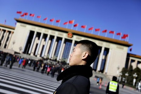 A soldier in plain clothes from the Chinese People's Liberation Army (PLA) stands guard in front of the Great Hall of the People, the venue A soldier in plain clothes from the Chinese People's Liberation Army (PLA) stands guard in front of the Great Hall of the People, the venue