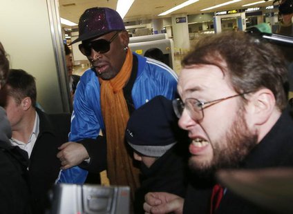 Bodyguards clear a path for former NBA basketball player Dennis Rodman (C) as journalists surround him upon his arrival from North Korea's P Bodyguards clear a path for former NBA basketball player Dennis Rodman (C) as journalists surround him upon his arrival from North Korea's P