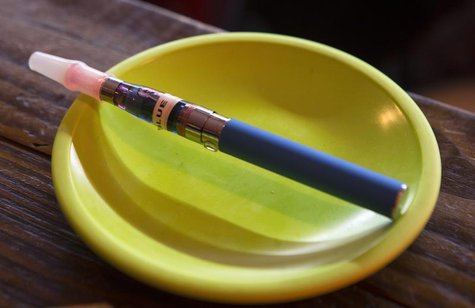 An e-cigarette sits in a tray on the bar at the Henley Vaporium in New York City December 18, 2013. REUTERS/Mike Segar An e-cigarette sits in a tray on the bar at the Henley Vaporium in New York City December 18, 2013. REUTERS/Mike Segar